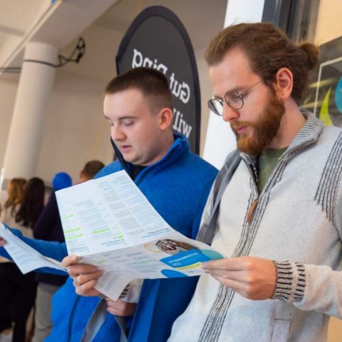 Unternehmenstag 2022: Studenten lesen den U-Tag Flyer